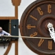 técnico ajustando la hora de un reloj de pared en la fachada de un edificio