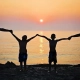 Imagen de familia con puesta de sol al fondo en la playa bienestar familiar técnicas quiropráctica Barcelona