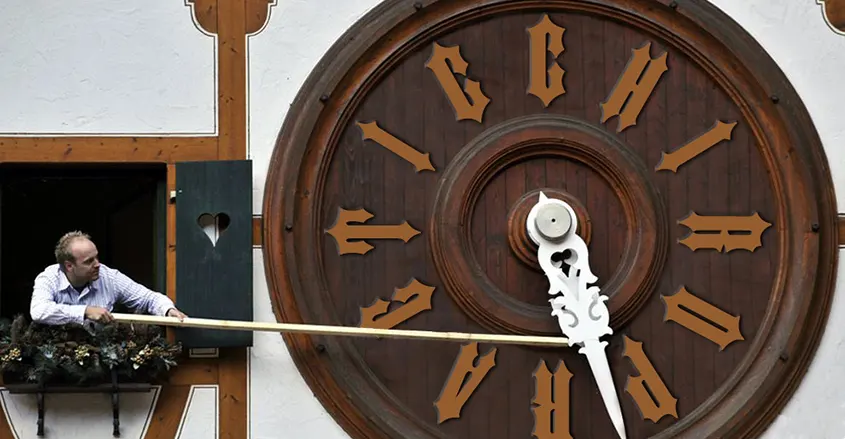 imagen de un hombre ajustando un reloj desde una ventana