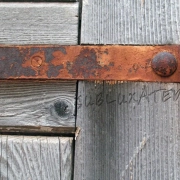 imagen con una puerta de madera con las bisagras oxidadas