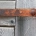 imagen con una puerta de madera con las bisagras oxidadas