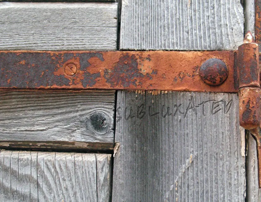 imagen con una puerta de madera con las bisagras oxidadas