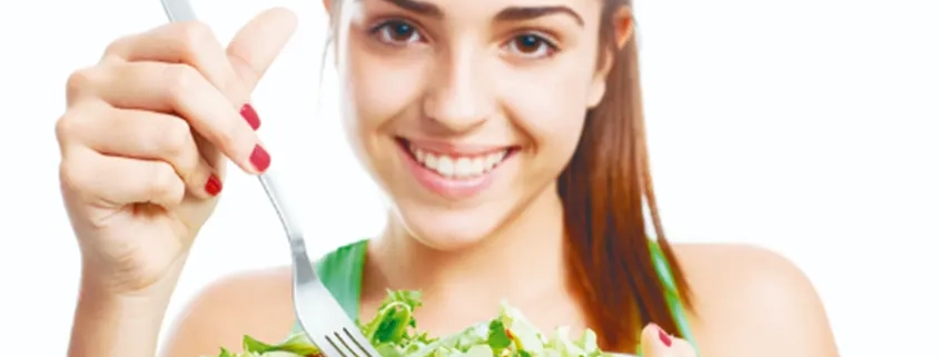 Foto de mujer joven comiendo comida sana ensalada quiropráctico Barcelona