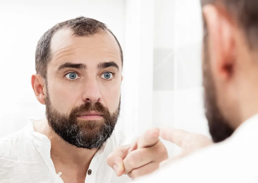 imagen de un hombre frente al espejo señalándose a si mismo quiropráctico Barcelona